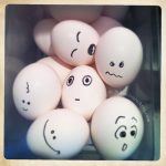 Faces drawn on eggs in a basket