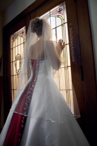 Bride looking through a glass door at the church for her wedding